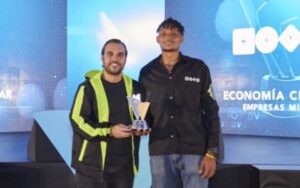 Dos hombres sosteniendo juntos un trofeo de premios AVA.