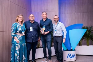 Una mujer y tres hombres, uno de los hombres sostiene premio AVA.