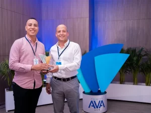 Dos hombres posando , juntos sostienen un trofeo de premios AVA.